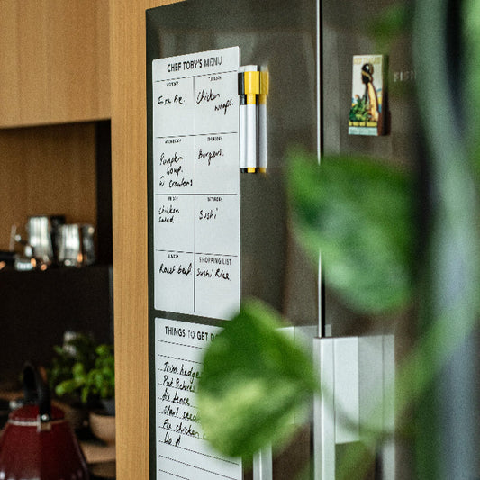 Magnetic Meal planner with meal plan on stainless fridge in a kitchen setting